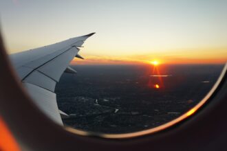 Looking out of the airplane window as the sun is setting over the city