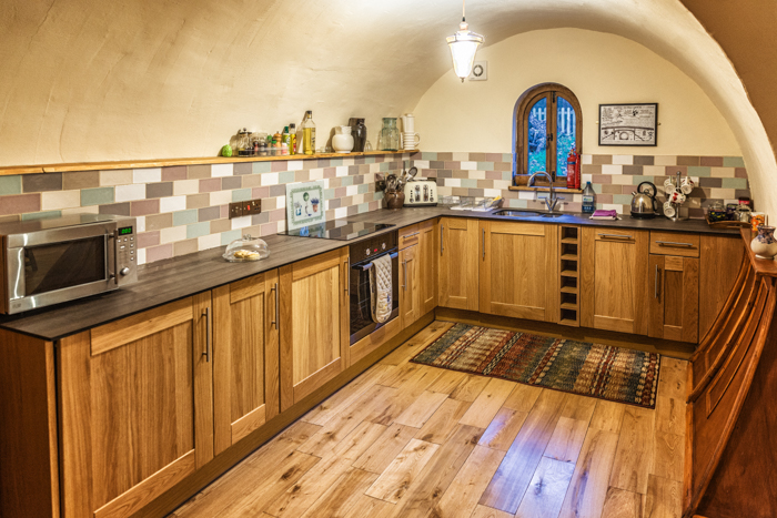 The modern kitchen at Pod Hollow at West STow Pods has everything you need for a comfortable stay including a dishwasher.