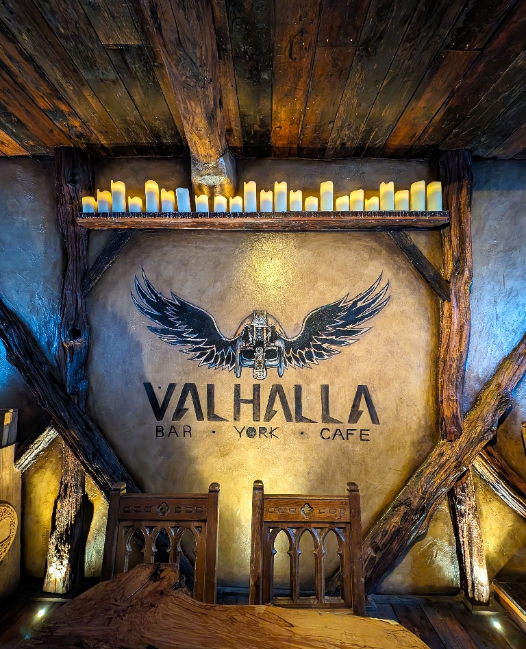 Valhalla in York upstairs with a mural on the wall backlit by candles